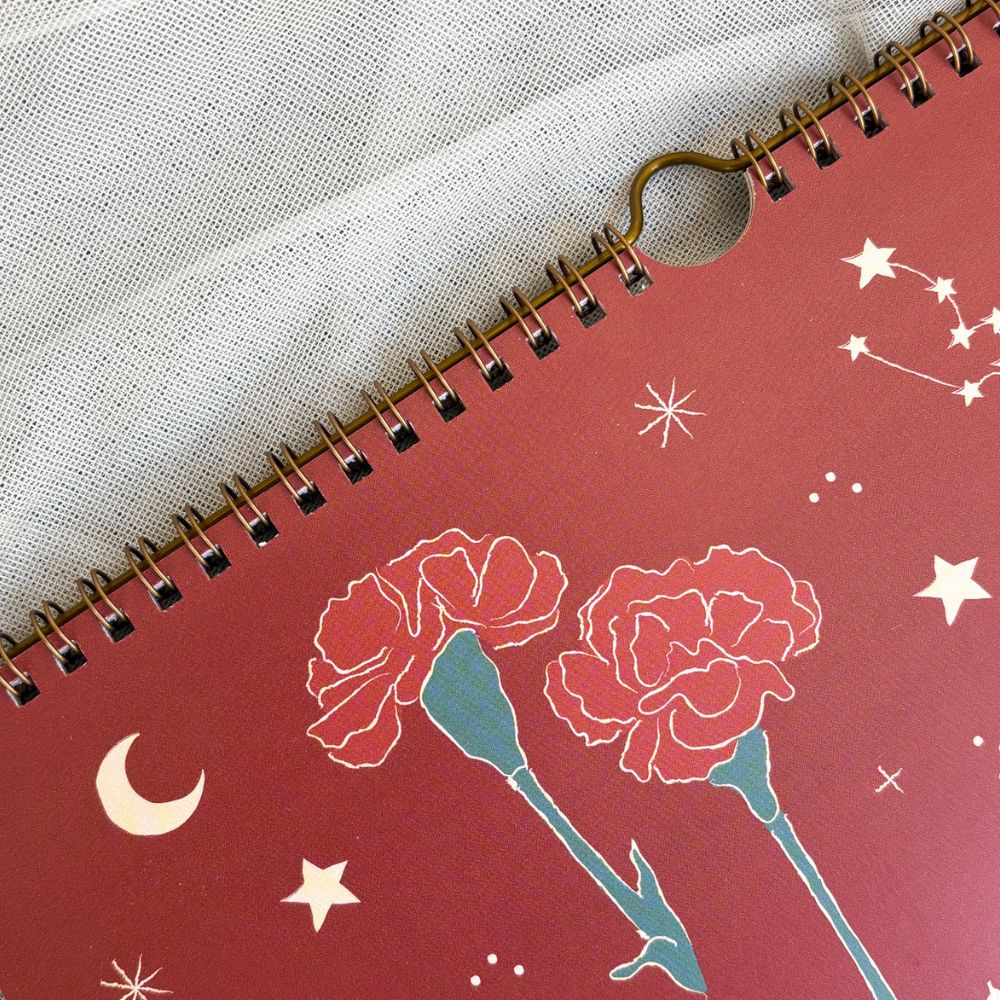 Calendar with bronze hanging with floral design on a red cover