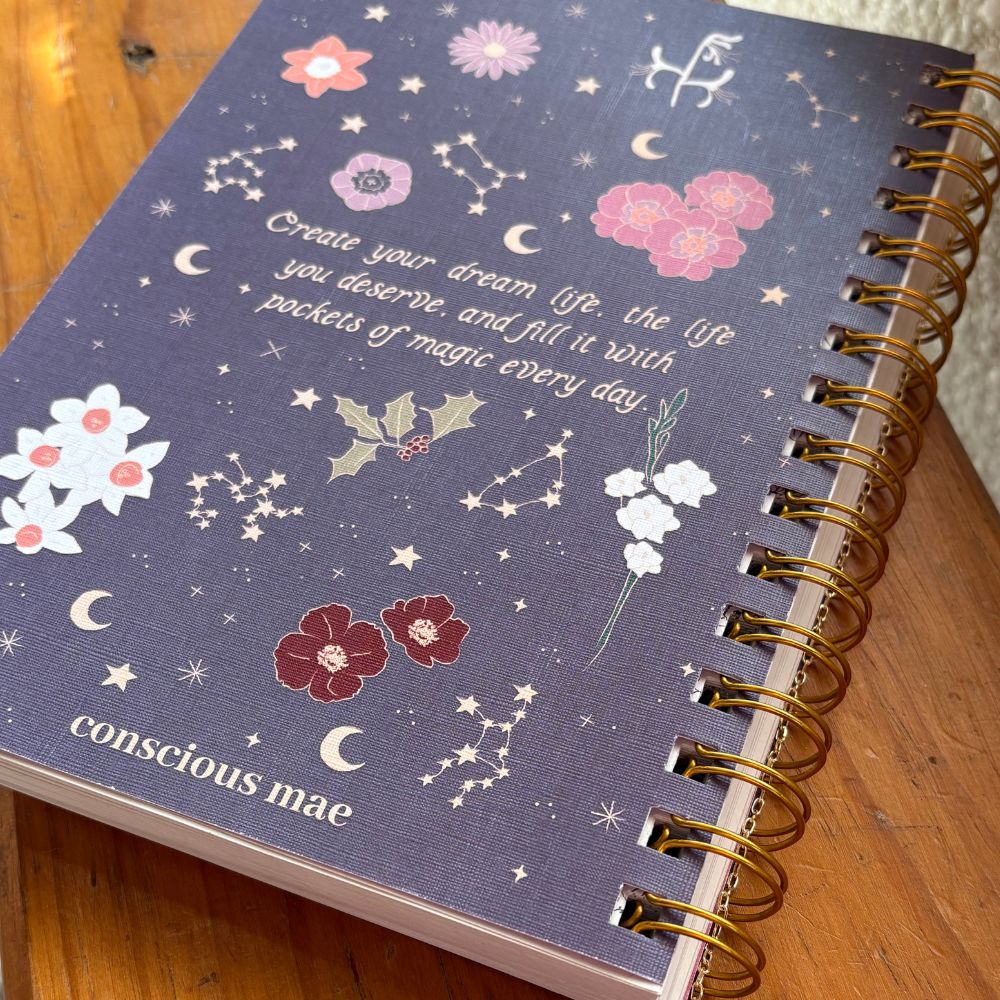 Purple 2026 diary with floral and celestial designs on a wooden surface
