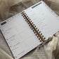 Open planner with monthly reflection page on a soft fabric background