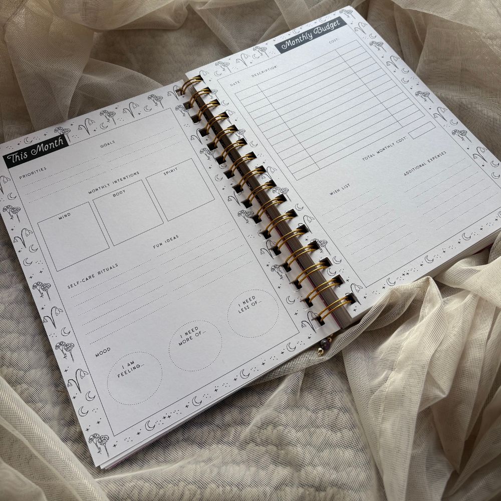Open planner with monthly planning and budget layout on a soft fabric background