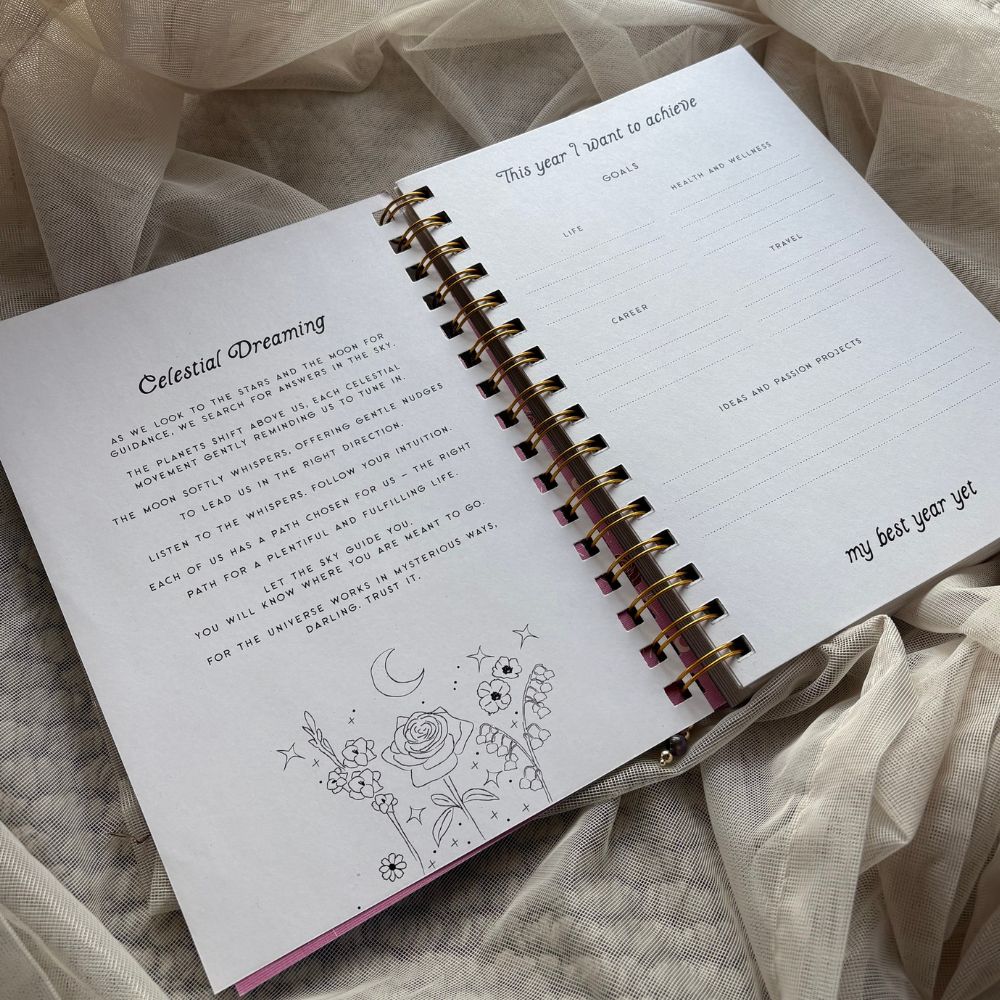 Open planner with spiral binding on a soft fabric background